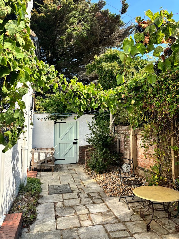 The vine-covered kitchen garden courtyard at Blue Waters with its pale green gate