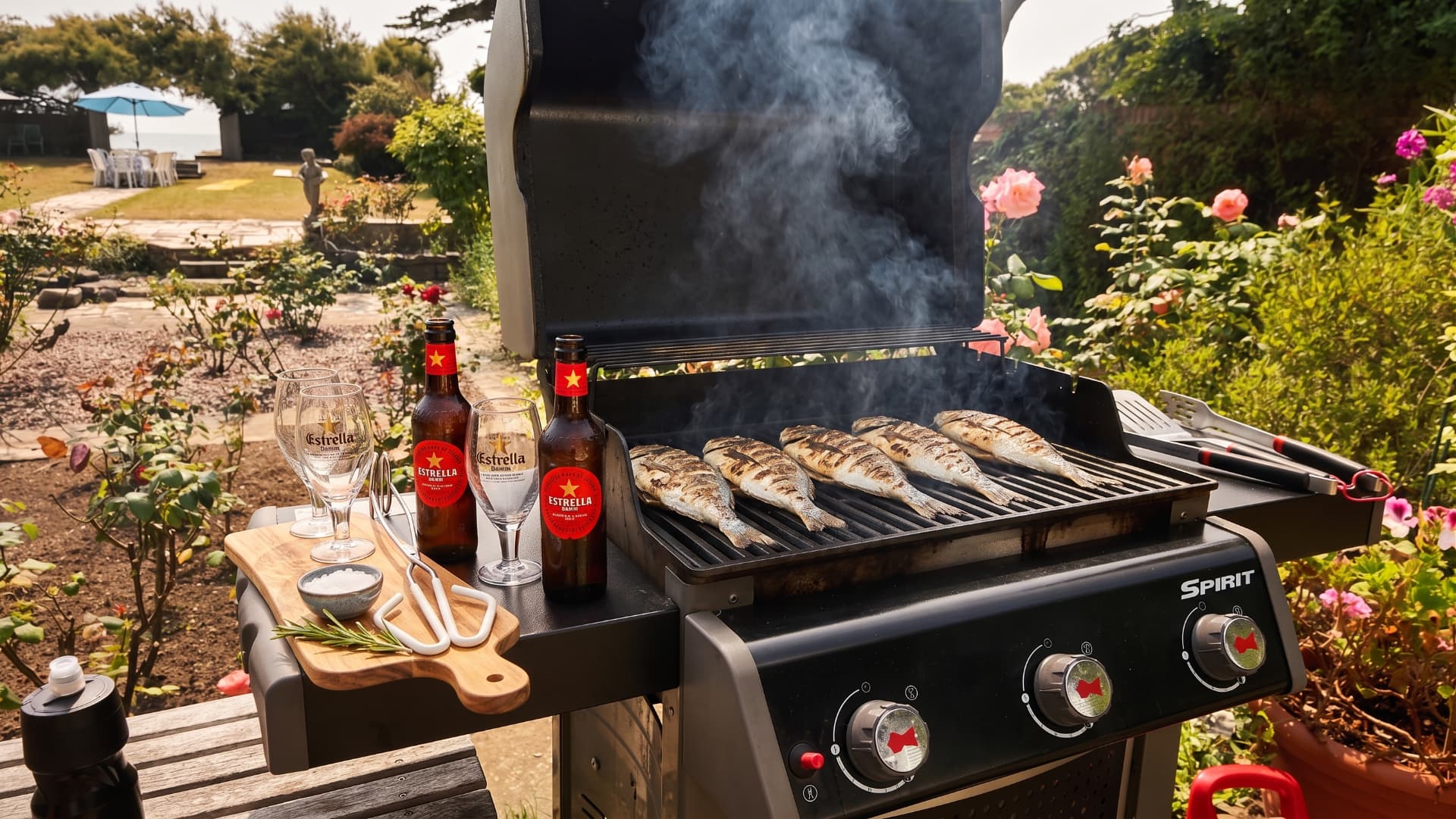 Fresh fish grilling on the barbecue in the garden at Blue Waters, with the lawn and sea behind