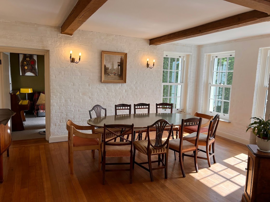 The dining table at Blue Waters set beneath candle-style wall lights, with the oval table seating ten