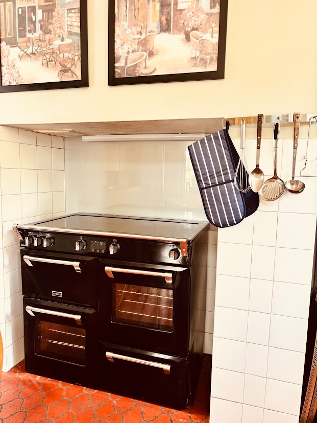 The black range cooker at Blue Waters with utensils hanging alongside